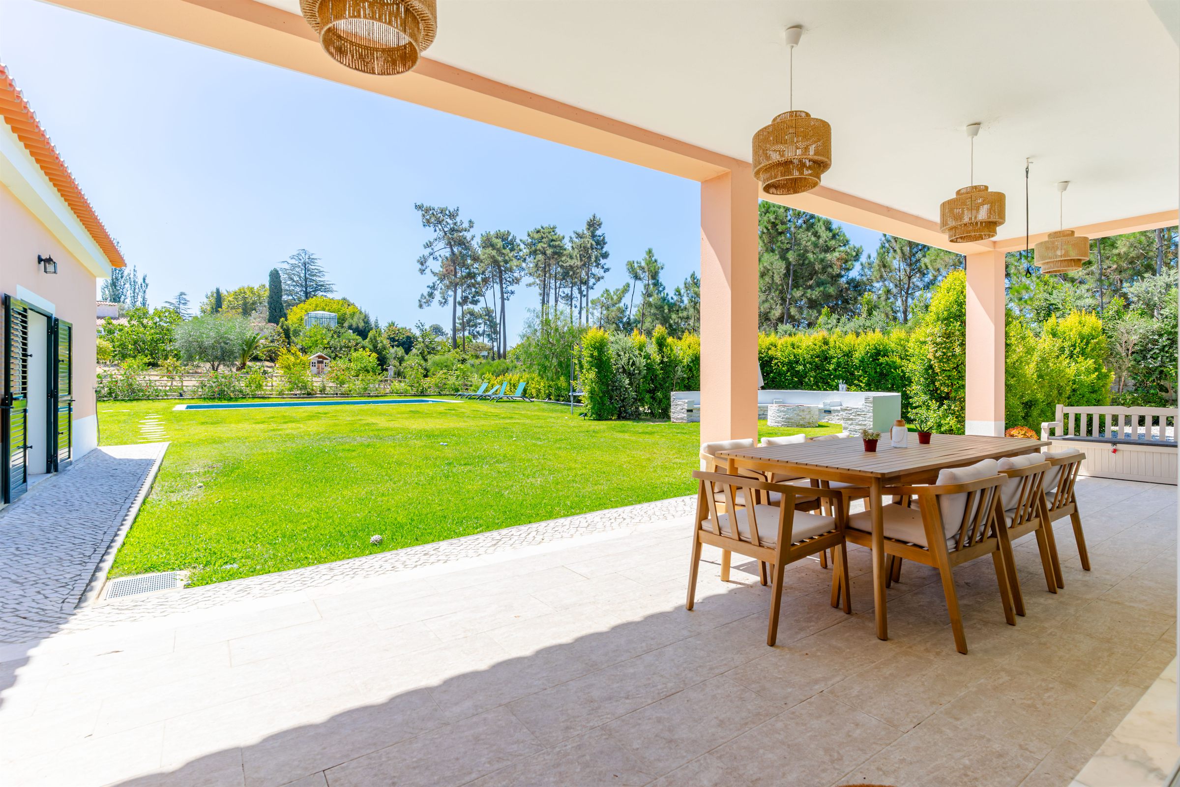 The covered terrace opening onto the garden and pool